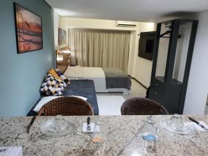 a hotel room with a bed and a table and chairs at Apartamento Praia do Centro Pipa in Pipa