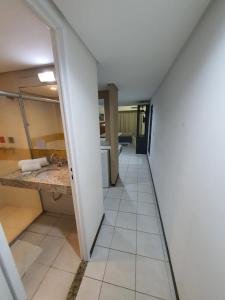 a hallway of a room with a sink and a mirror at Apartamento Praia do Centro Pipa in Pipa