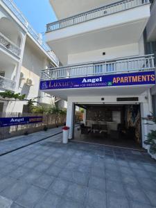 Una entrada a un edificio con una pancarta morada. en Luxury Angel Apartments 1, en Paralia Katerinis