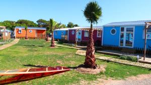 un groupe de maisons colorées et un palmier dans l'établissement Camping 3 Estrellas, à Gavà