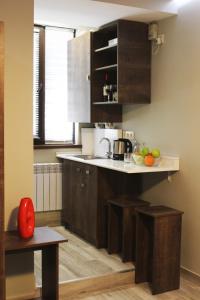 una cocina con armarios marrones y una barra con frutas. en Studio rooms on the 2nd Floor, en Ereván