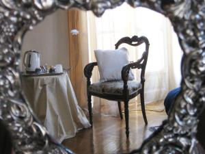 a mirror reflecting a chair with a pillow on it at A Casa Armenia B&B in Turin