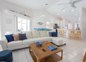 un soggiorno con un divano bianco e un tavolo di Blue Breeze Retreat a Vero Beach