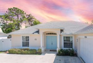 una casa bianca con un garage blu di Blue Breeze Retreat a Vero Beach