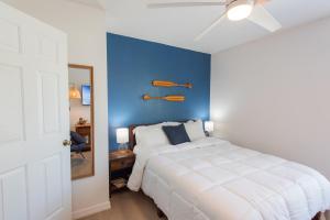 una camera da letto con un letto bianco con una parete blu di Blue Breeze Retreat a Vero Beach Altre 39 foto