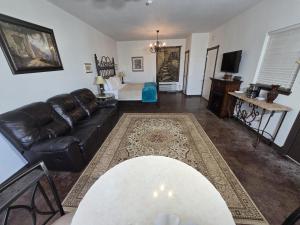 un soggiorno con un divano in pelle e un tavolo di NEW Pickleball, Cornhole, Pool, Patio & Hot Tub a Fredericksburg
