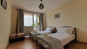 a bedroom with two beds and a window at L'oasis d'Agadir - Agadir's hidden Oasis in Agadir