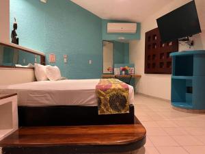 a bedroom with a bed and a flat screen tv at Cerezas in Cancún
