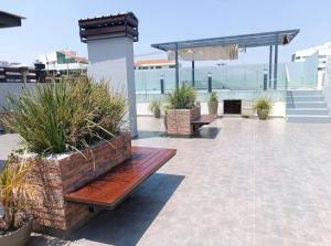 a patio with benches and plants on a building at Departamento Cala Cala in Cochabamba