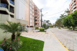 a city street with a bench and flowers and buildings at Apartamento Garden Caiobá com Piscina Praia Brava in Matinhos