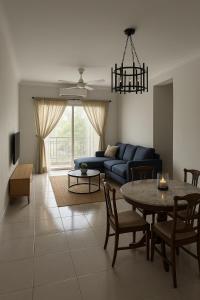 a living room with a blue couch and a table at Angsana Raintree Batu Caves with balcony 3Bedroom 2Bathroom in Batu Caves