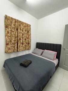 a bed with a blue blanket and a window at Angsana Raintree Batu Caves with balcony 3Bedroom 2Bathroom in Batu Caves +15 photos