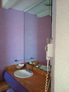 a bathroom with a sink and purple walls at Cerezas in Cancún