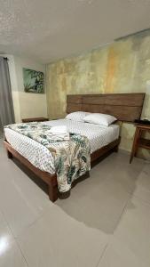a bedroom with a bed with a wooden head board at Departamento Privado y Amplio en Zona Norte con Wifi cerca Centro in Mérida