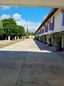 an empty street next to a building with trees at Cerezas in Cancún +2 photos