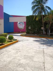 a building with a palm tree and a clock at Cerezas in Cancún