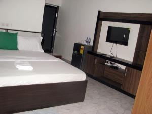 东勒贡Hgl Guest House的一间带床和平板电视的卧室