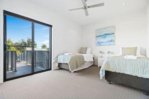 a bedroom with two beds and a balcony at Aqua Shores 3 Bedroom - Newly renovated with Wifi, Linen, Netflix and AC in Huskisson
