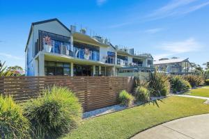 a large house with a fence and some plants at Aqua Shores 3 Bedroom - Newly renovated with Wifi, Linen, Netflix and AC in Huskisson