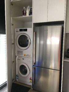 a kitchen with a refrigerator and a washer and dryer at Konayuki Apartment 1 in Falls Creek