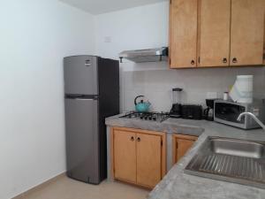 a kitchen with a stainless steel refrigerator and wooden cabinets at Linda Casa en Zona Mitras in Monterrey