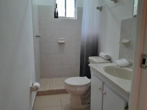 a white bathroom with a toilet and a sink at Linda Casa en Zona Mitras in Monterrey +22 photos