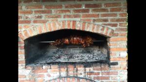 a brick oven with meat cooking in it at B&B Plitvica Lodge in Plitvica selo