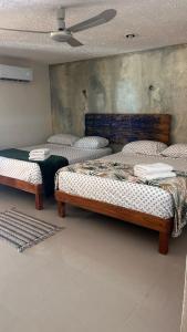 2 camas individuales en una habitación con techo en Hospedaje Cálido y Céntrica, en Mérida