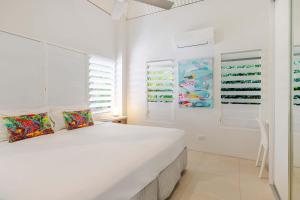 a white bedroom with a bed and a closet at Serenity Villa with heated POOL & Beach access in Port Douglas +21 photos