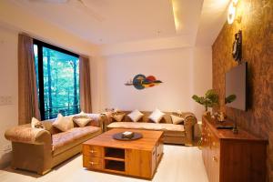 a living room with a couch and a table at Hill Crest By Xaria Luxury Homes 2BHK Apartment in Dharampur