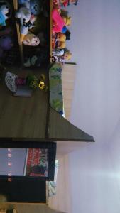 a desk with a shelf with stuffed animals and books at Apartamento Mobiliado in Guaíba