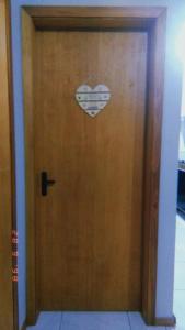 a wooden door with a heart on it at Apartamento Mobiliado in Guaíba
