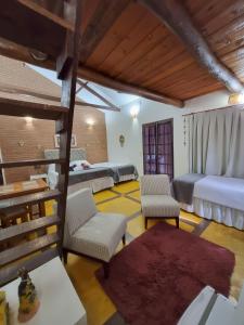 a bedroom with two beds and two chairs at Pousada Villa dos Quilombolas in São Bento do Sapucaí +132 photos