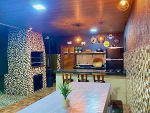 a large kitchen with a table and a stove at Casa com área gourmet, acomoda até 11 pessoas in Brusque