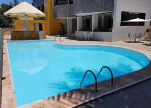a large blue swimming pool in front of a building at Flat vista mar in Cabedelo