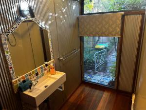 ein Badezimmer mit Waschbecken, Spiegel und Fenster in der Unterkunft South Terrace Studio - Walk to Everything ! in South Fremantle