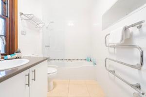 a white bathroom with a tub and a sink at Magnolia on Colville - Historic Riverside Elegance in Hobart +19 photos