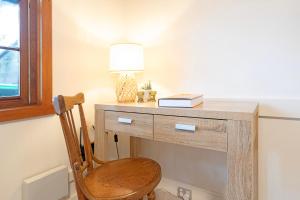 a wooden desk with a lamp and a wooden chair at Magnolia on Colville - Historic Riverside Elegance in Hobart