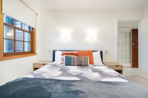a bedroom with a bed and a window at Magnolia on Colville - Historic Riverside Elegance in Hobart
