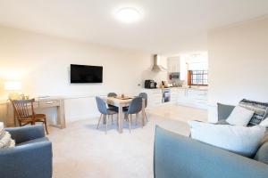 a living room with a table and chairs and a kitchen at Magnolia on Colville - Historic Riverside Elegance in Hobart