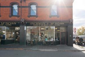 a restaurant with tables and chairs in front of a building at Magnolia on Colville - Historic Riverside Elegance in Hobart