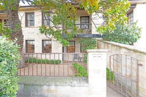an iron gate in front of a building at Magnolia on Colville - Historic Riverside Elegance in Hobart