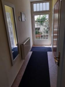 a hallway with a mirror and a door with a window at U paní malířky in Valtice