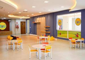 ein Wartezimmer mit Tischen und Stühlen sowie einem Spielbereich in der Unterkunft Solar das Águas Park Resort, Ap para Temporada in Olímpia