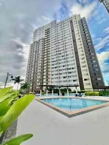 Un gran edificio con una piscina en frente. en The Penthouse - 3BR Bi-Level Avida Aspira Tower 1, en Cagayan de Oro