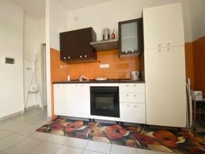 a kitchen with a stove and a white refrigerator at Casa Noè - cozy home with big terrace and private box in Turin