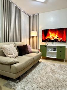 Una sala de estar con un sofá y una chimenea. en The Penthouse - 3BR Bi-Level Avida Aspira Tower 1, en Cagayan de Oro