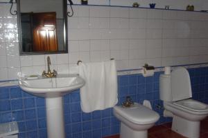 a blue and white bathroom with a sink and a toilet at Señorío de Monterruiz in Casas de Santa Cruz