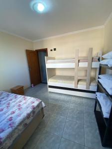 a bedroom with two bunk beds in a room at APÊ VISTA MAR, 20mts DA PRAIA, ESPAÇOSO E ACONCHEGANTE-56m2- WIFI- 1 DORM-ELEVADOR- 6 PESSOAS in Praia Grande