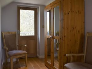 a room with a door and two chairs and a window at Hill Farm Cottage in Stretham +7 photos